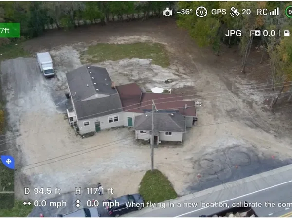 an aerial view of a house with garden space and sitting area