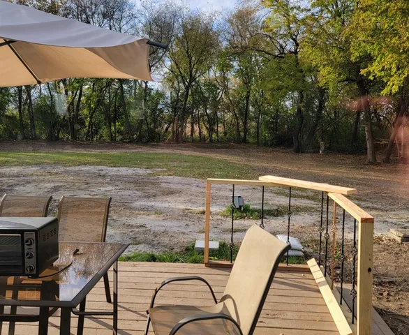 a view of house with patio outdoor seating and covered with trees