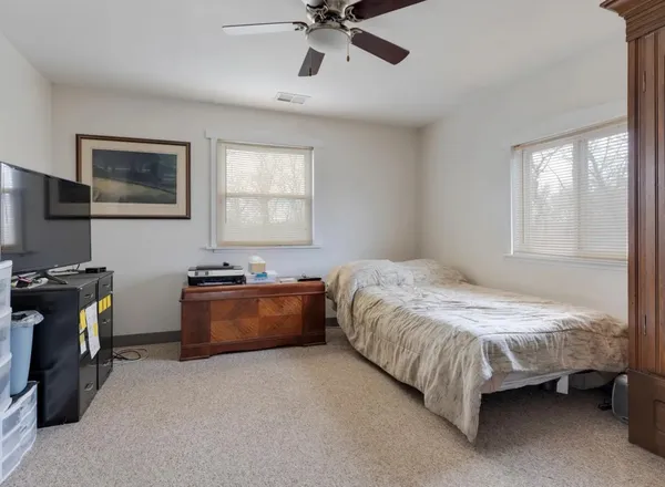 a spacious bedroom with a bed and a chandelier