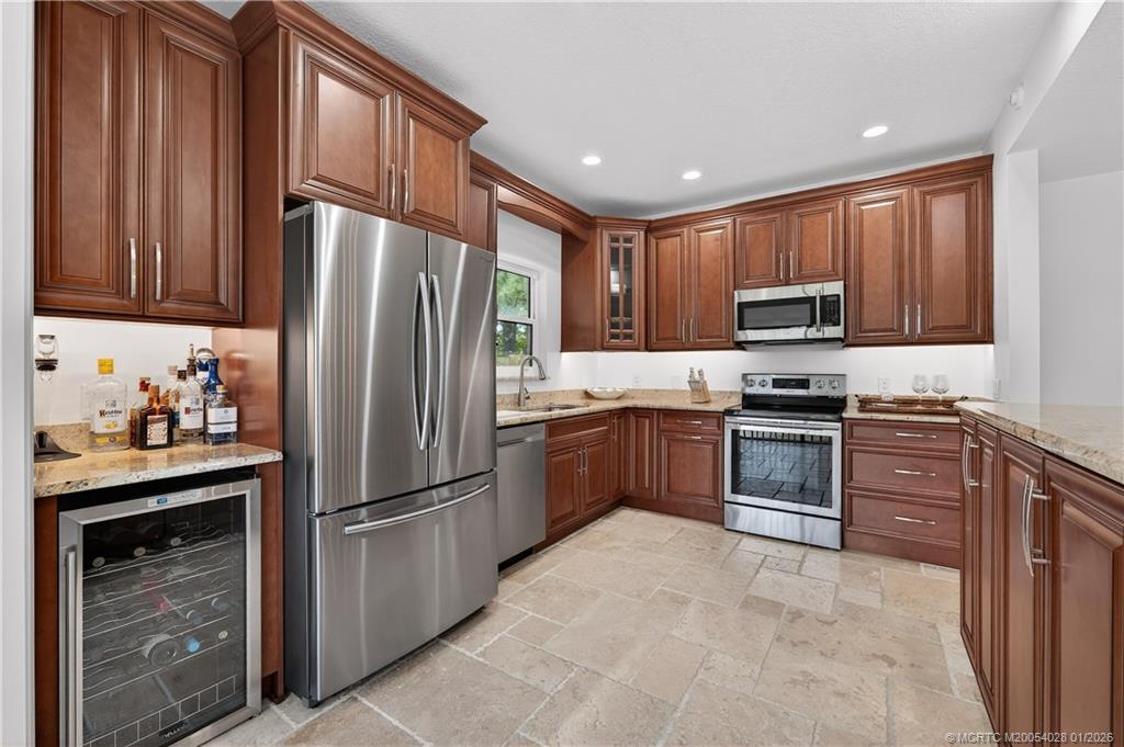 13204 Harbour Ridge Boulevard, Unit 2A Palm City, FL 34990 - Photo 11 of 38 a kitchen with kitchen island granite countertop stainless steel appliances and cabinets