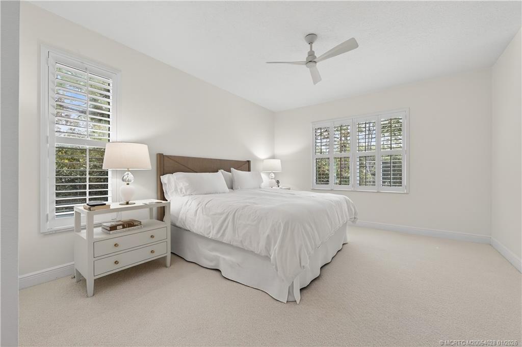 13204 Harbour Ridge Boulevard, Unit 2A Palm City, FL 34990 - Photo 19 of 38 a bedroom with a bed a chandelier and a window