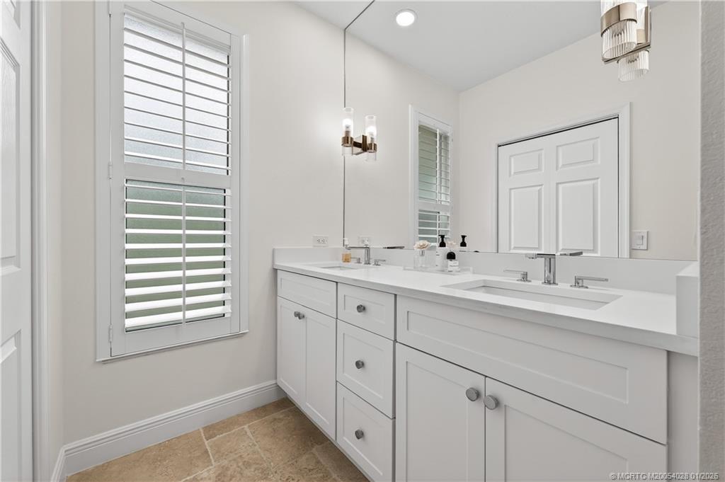 13204 Harbour Ridge Boulevard, Unit 2A Palm City, FL 34990 - Photo 20 of 38 a spacious bathroom with double sink and a mirror