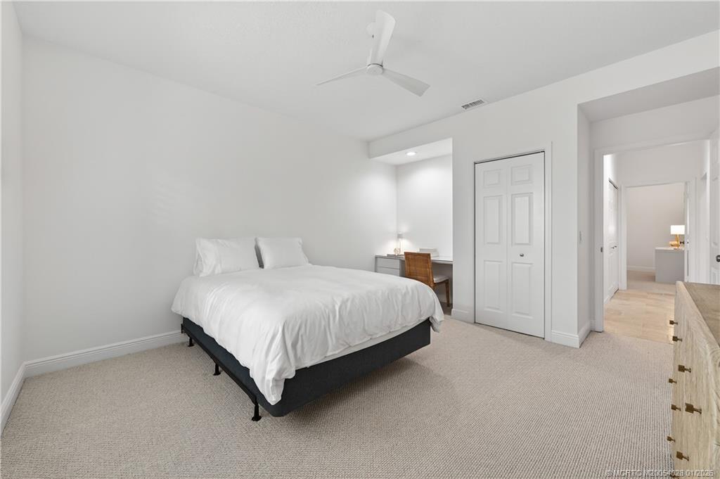 13204 Harbour Ridge Boulevard, Unit 2A Palm City, FL 34990 - Photo 23 of 38 a spacious bedroom with a bed and a lamp