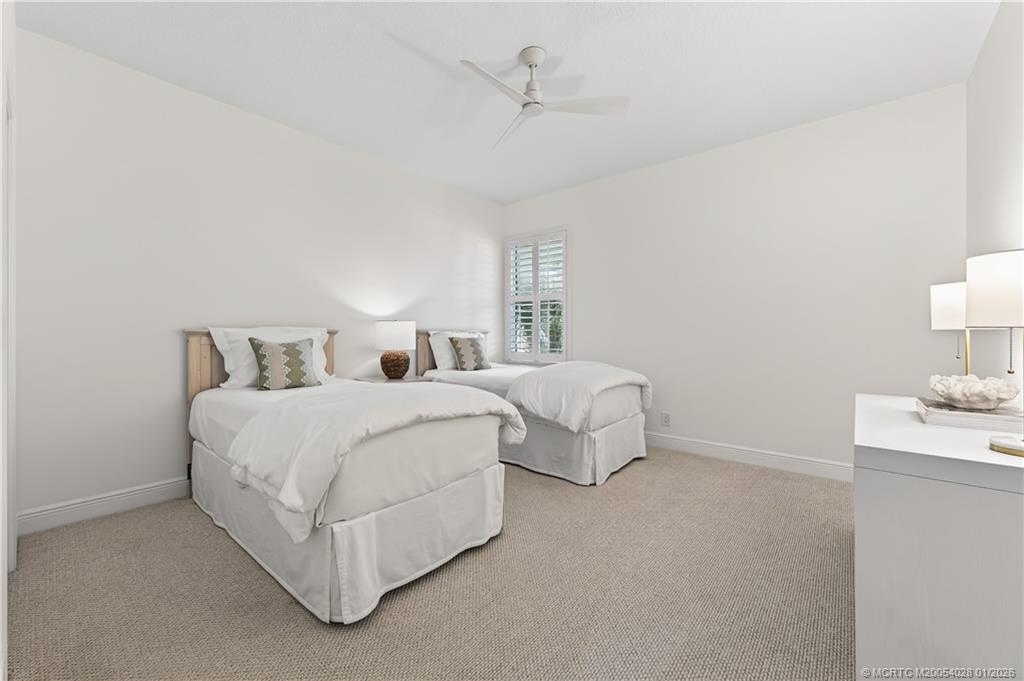 13204 Harbour Ridge Boulevard, Unit 2A Palm City, FL 34990 - Photo 24 of 38 a spacious bedroom with a bed and a lamp