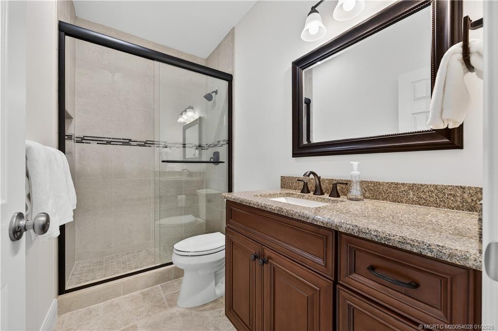 13204 Harbour Ridge Boulevard, Unit 2A Palm City, FL 34990 - Photo 25 of 38 a bathroom with a granite countertop sink mirror vanity and toilet