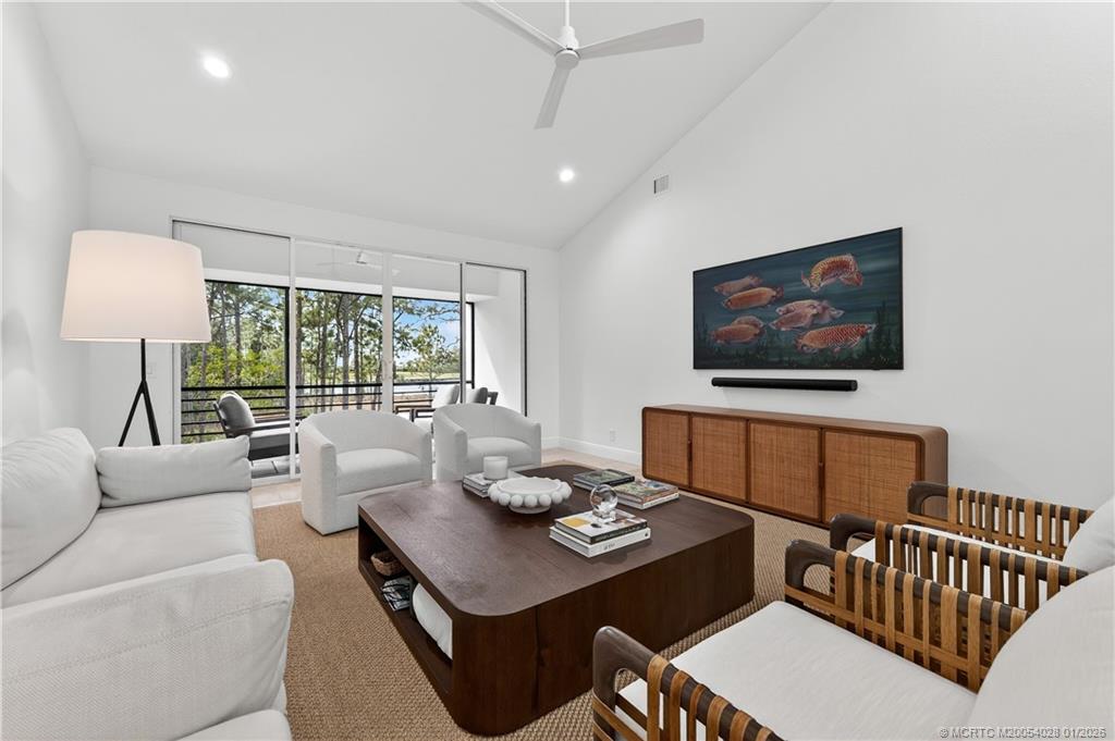 13204 Harbour Ridge Boulevard, Unit 2A Palm City, FL 34990 - Photo 6 of 38 a living room with furniture a flat screen tv and a large window