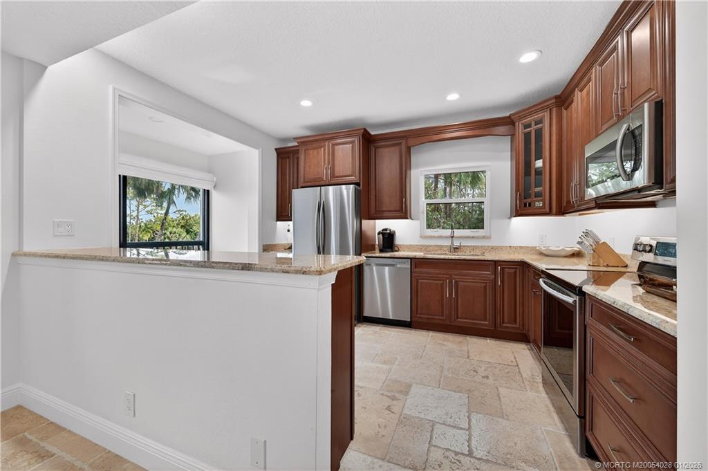 13204 Harbour Ridge Boulevard, Unit 2A Palm City, FL 34990 - Photo 9 of 38 a large kitchen with stainless steel appliances granite countertop a large stove a sink dishwasher and a refrigerator