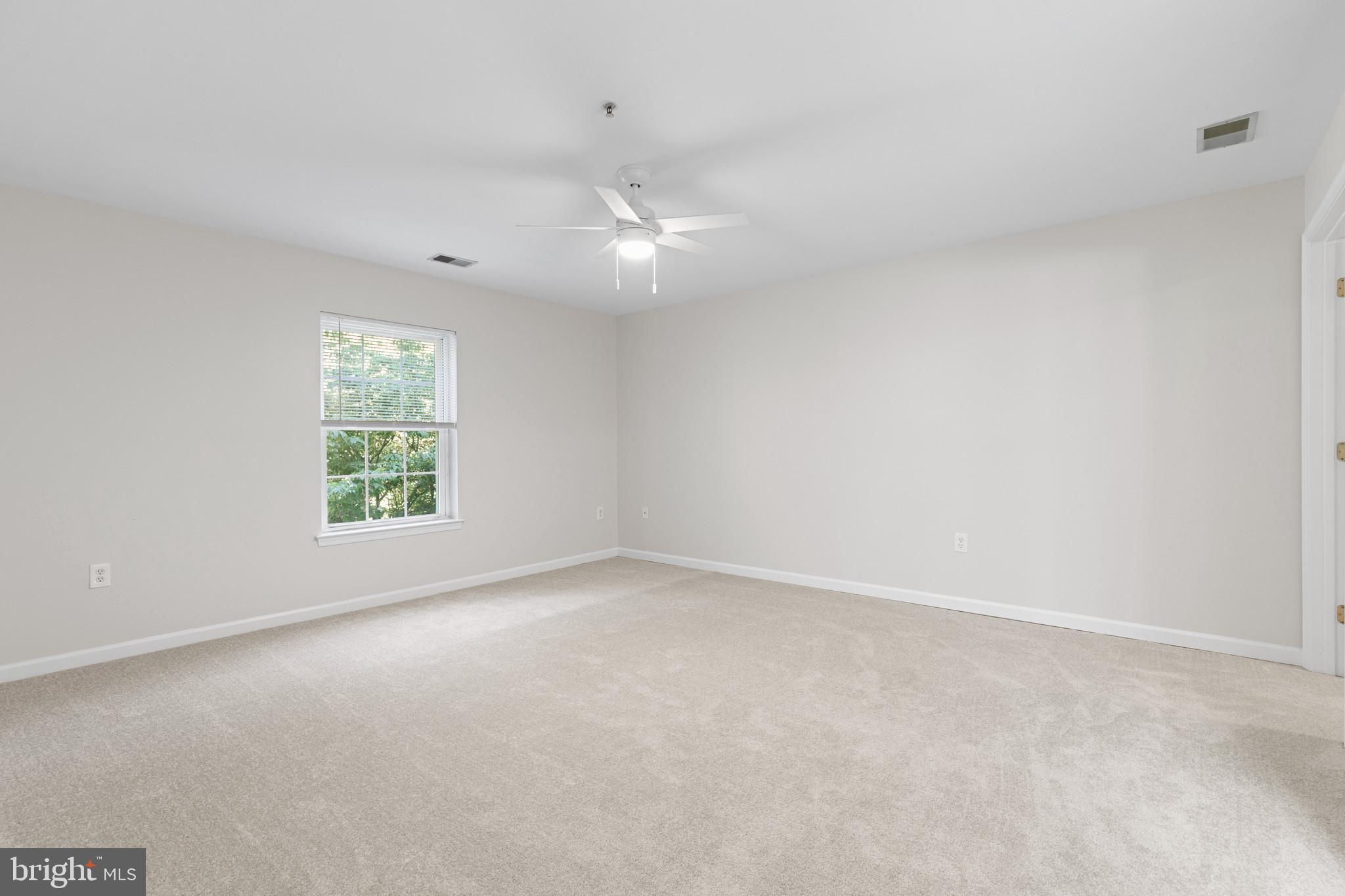 6504 Ridenour Way East, Unit 2C Sykesville, MD 21784 - Photo 22 of 32 an empty room with a window and a fan