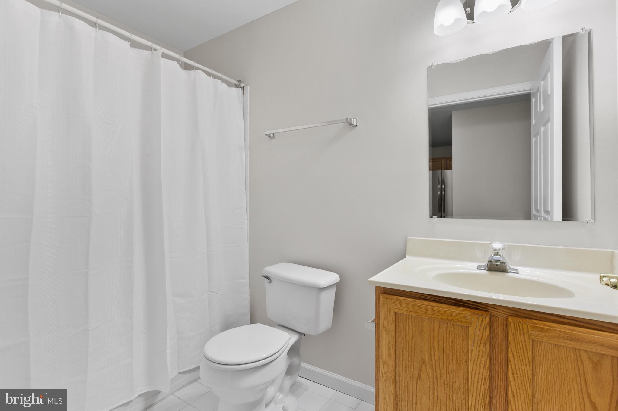 6504 Ridenour Way East, Unit 2C Sykesville, MD 21784 - Photo 29 of 32 a bathroom with a sink a toilet and a mirror