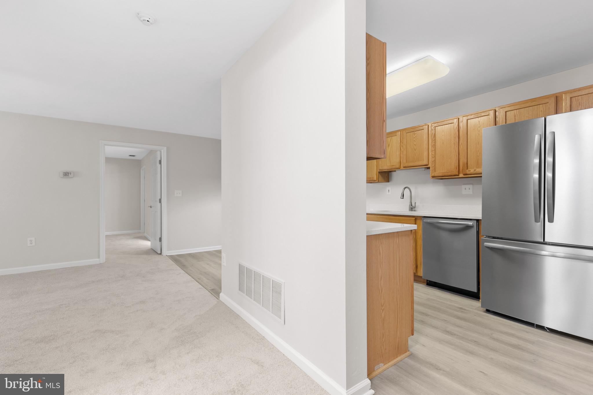 6504 Ridenour Way East, Unit 2C Sykesville, MD 21784 - Photo 4 of 32 a kitchen with a refrigerator a stove top oven a refrigerator and wooden floor
