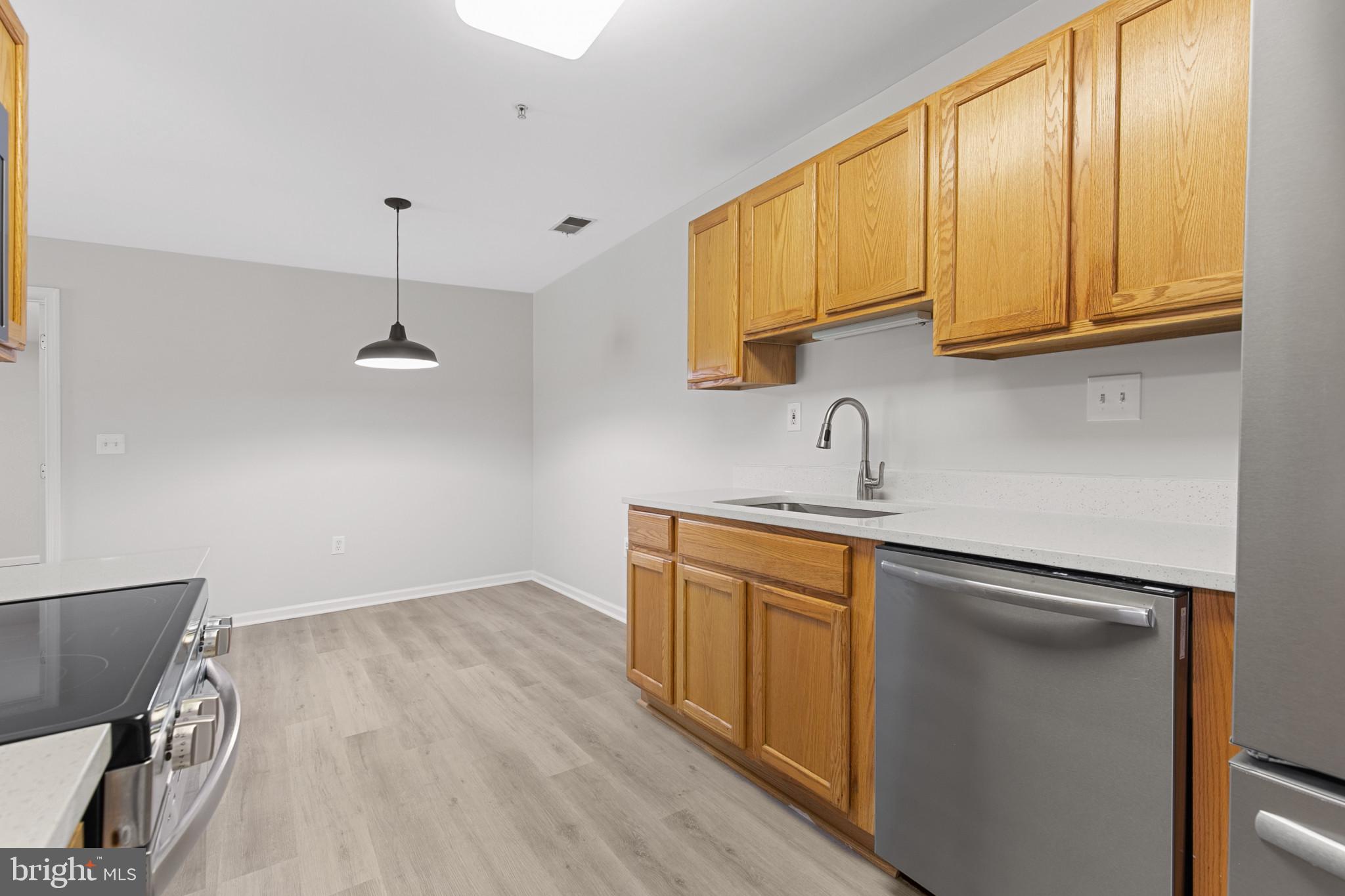 6504 Ridenour Way East, Unit 2C Sykesville, MD 21784 - Photo 6 of 32 a kitchen with stainless steel appliances granite countertop a sink a stove and a wooden floors