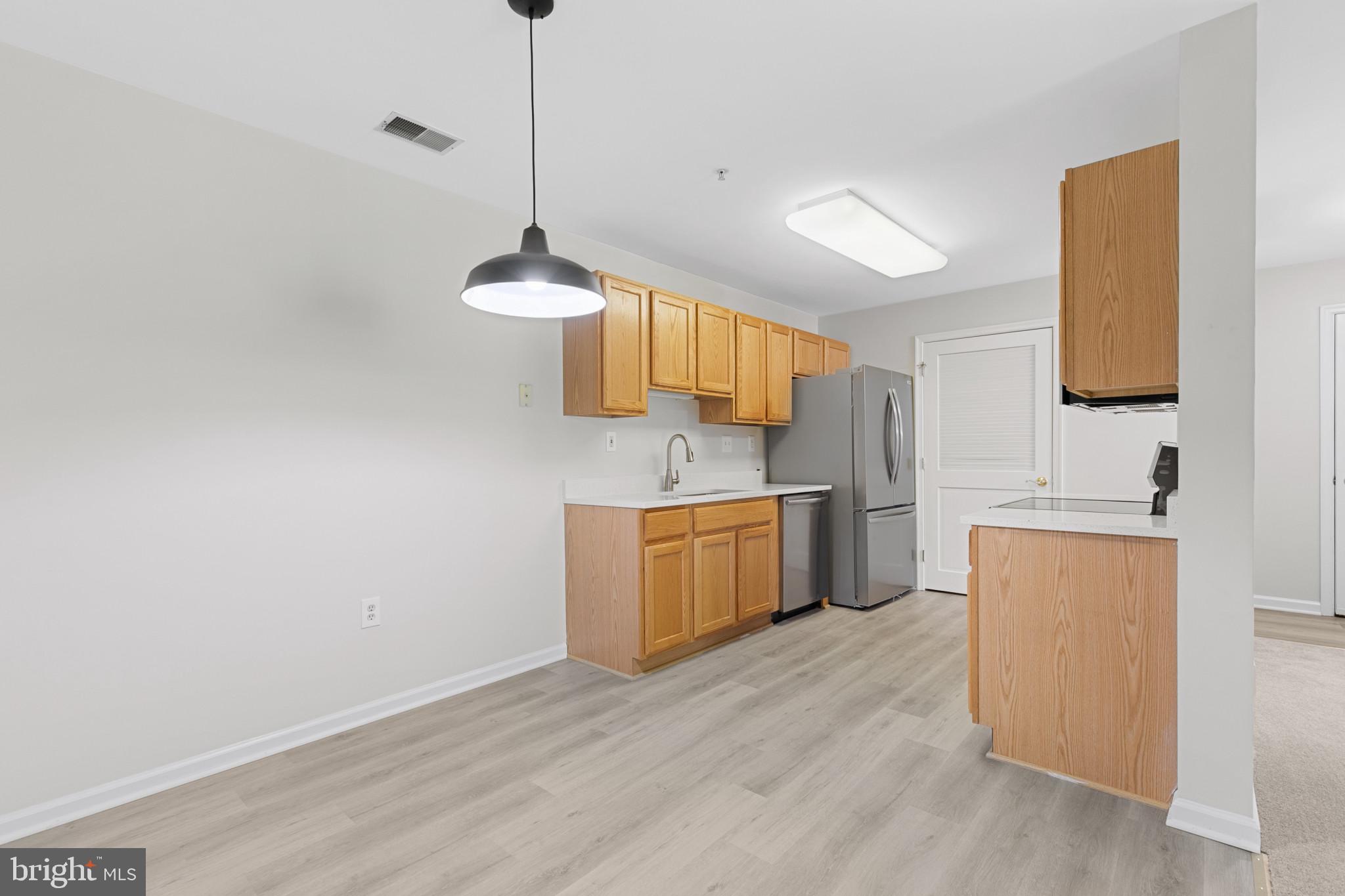 6504 Ridenour Way East, Unit 2C Sykesville, MD 21784 - Photo 10 of 32 a kitchen with a sink cabinets and wooden floor
