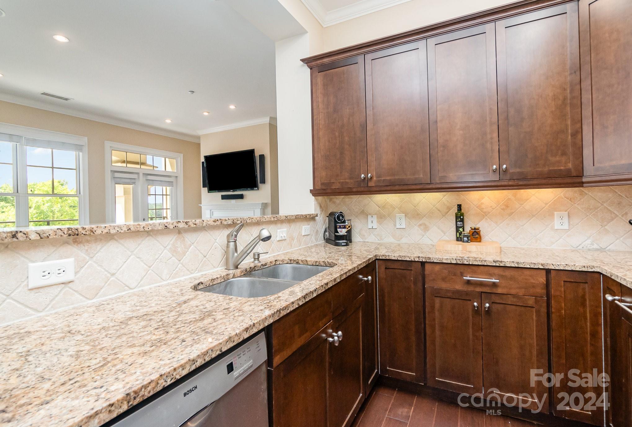 5425 Closeburn Road, Unit 213 Charlotte, NC 28210 - Photo 16 of 32 a kitchen with granite countertop a sink and a wooden cabinets