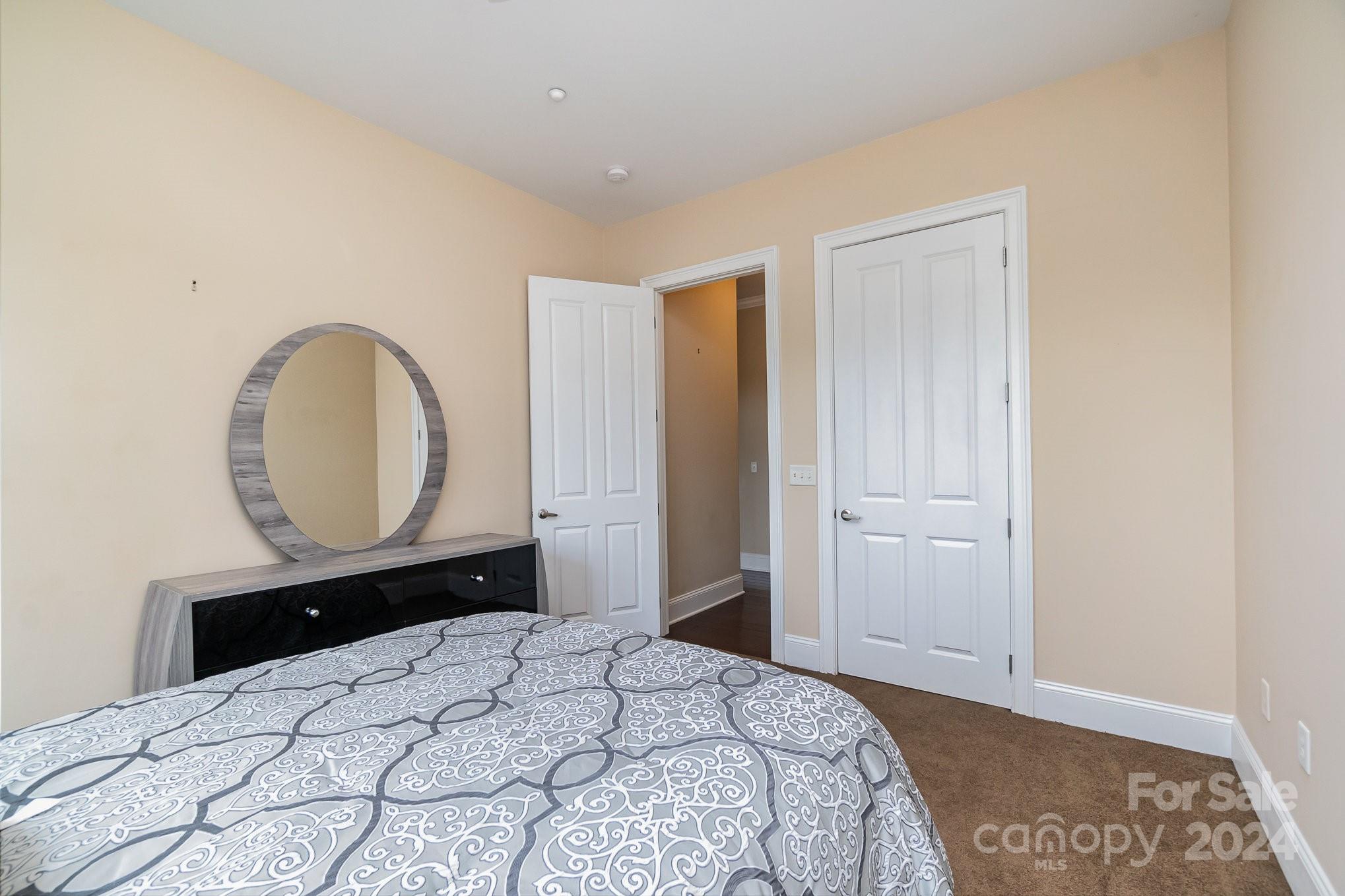 5425 Closeburn Road, Unit 213 Charlotte, NC 28210 - Photo 26 of 32 a bedroom with a bed and a mirror