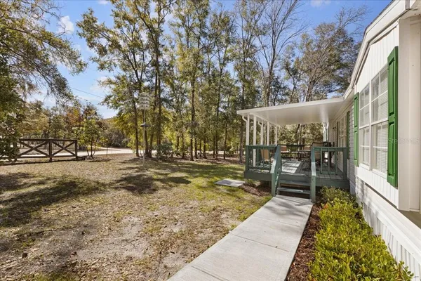 a view of a large house with a yard and large trees