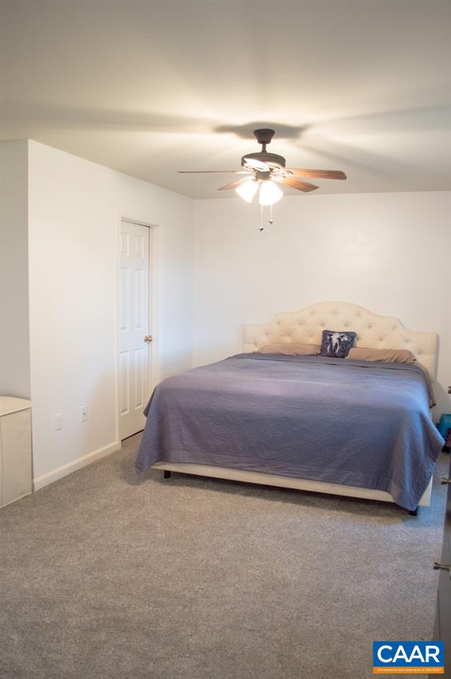 173 Top Ridge Road Stanardsville, VA 22973 - Photo 19 of 40 a bedroom with a bed and a chandelier