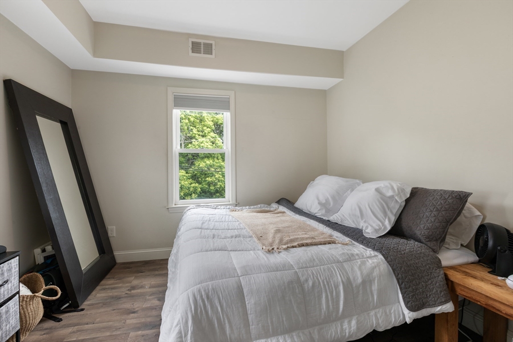 10 Elliott Place, Unit 3F Peabody, MA 01960 - Photo 7 of 15 a bed sitting in a bedroom next to a window