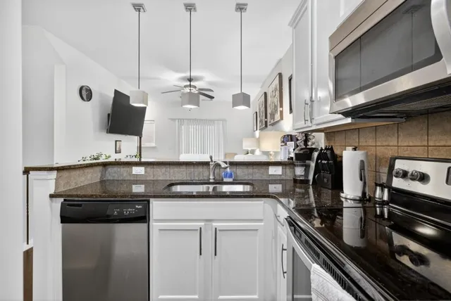 a kitchen with stainless steel appliances granite countertop a sink a stove and a refrigerator