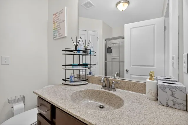 a bathroom with a granite countertop sink a toilet and bathtub