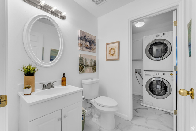 1147 West State Road Lehi, UT 84043 - Photo 15 of 31 White vanity with integrated sink and chrome faucet, oval mirror, toilet, and marble-look flooring