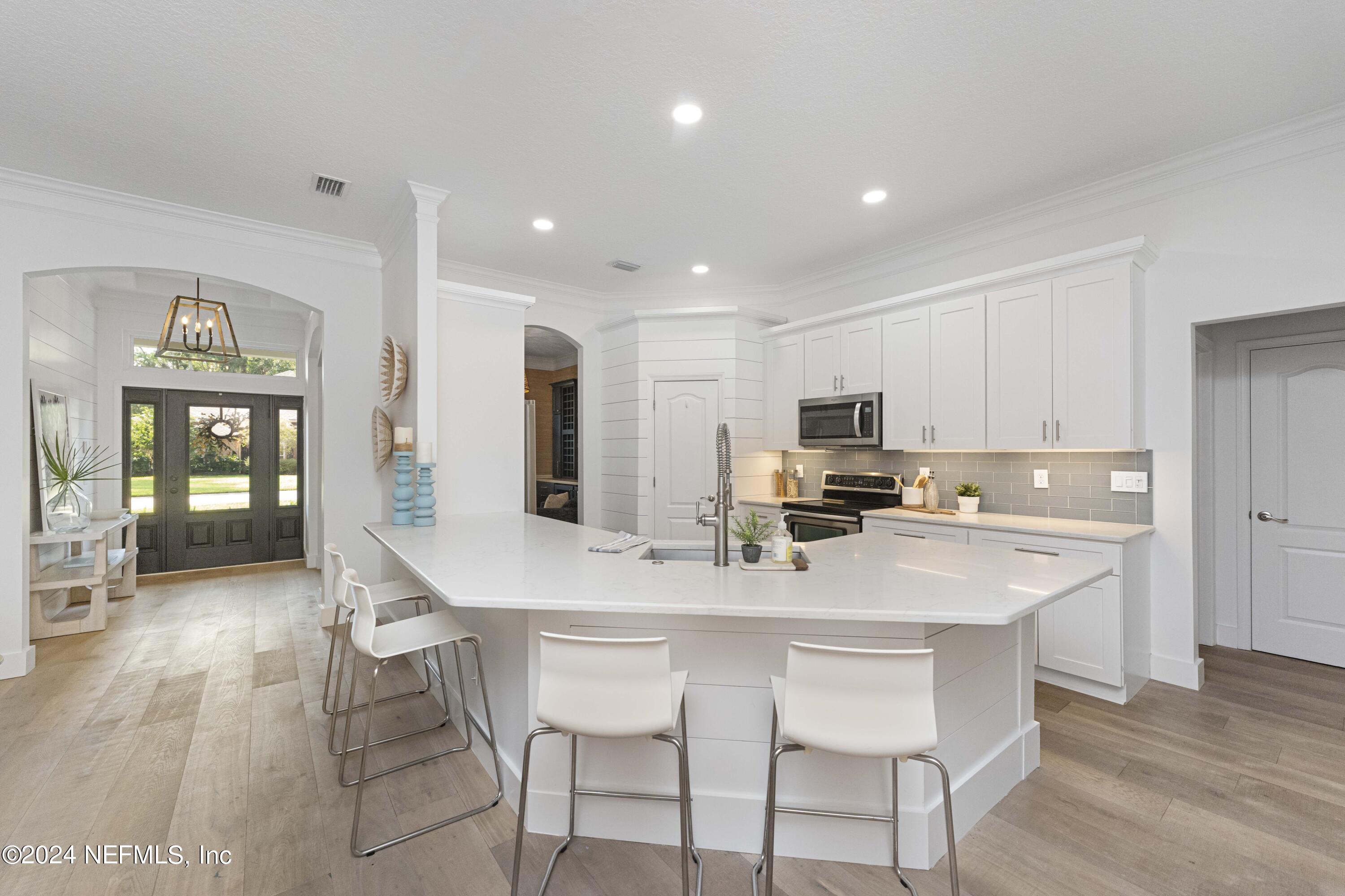 804 Mill Stream Road Ponte Vedra Beach, FL 32082 - Photo 14 of 67 a kitchen with a dining table chairs refrigerator and microwave