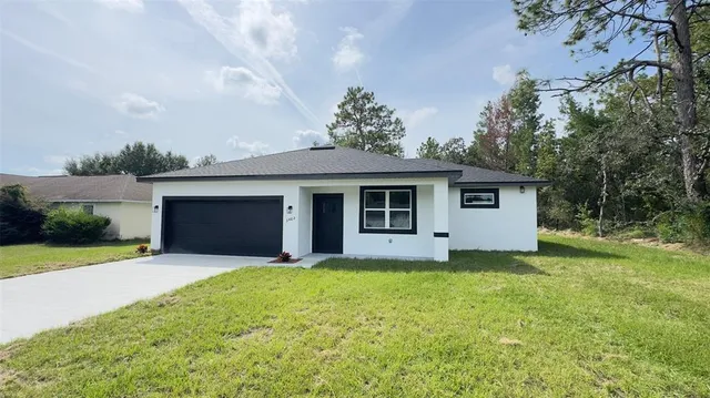 a front view of a house with yard and garage
