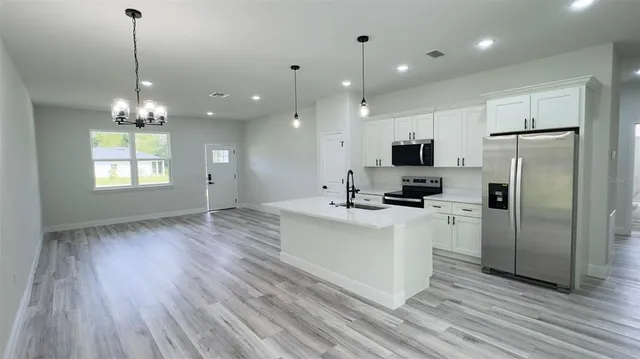 a view of a kitchen with a sink a refrigerator and a window