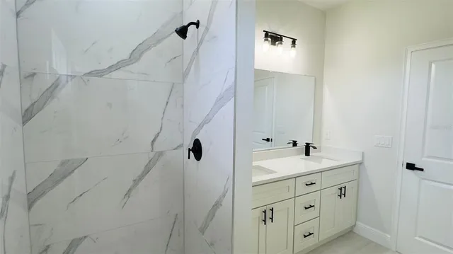 a bathroom with a double vanity sink a mirror and shower
