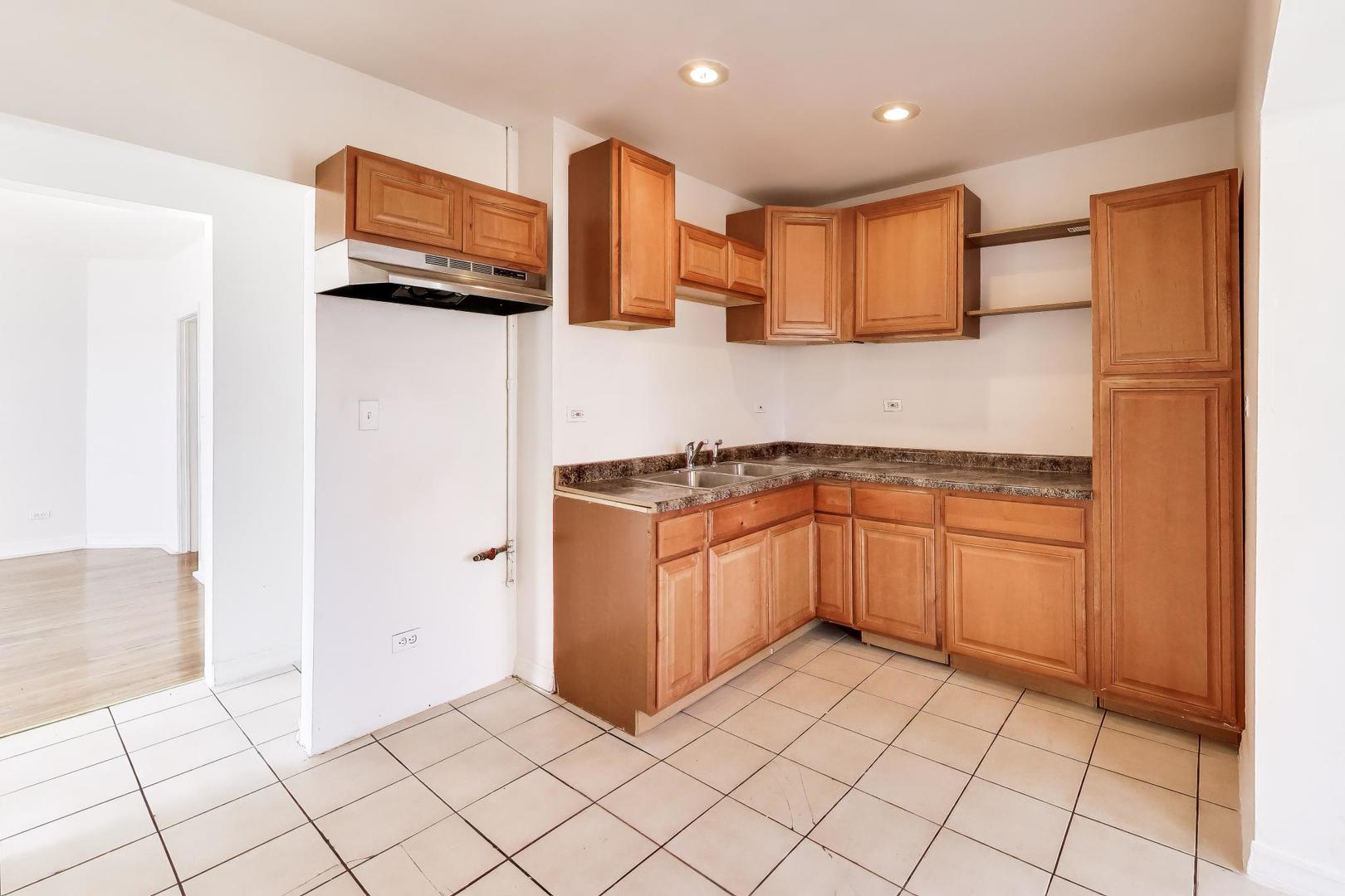 6853 South Perry Avenue Chicago, IL 60621 - Photo 14 of 28 a kitchen with stainless steel appliances a sink and a refrigerator
