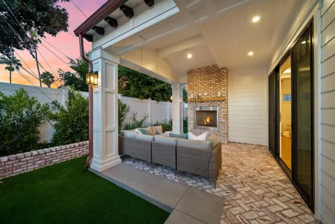 a living room with furniture a fireplace and a floor to ceiling window