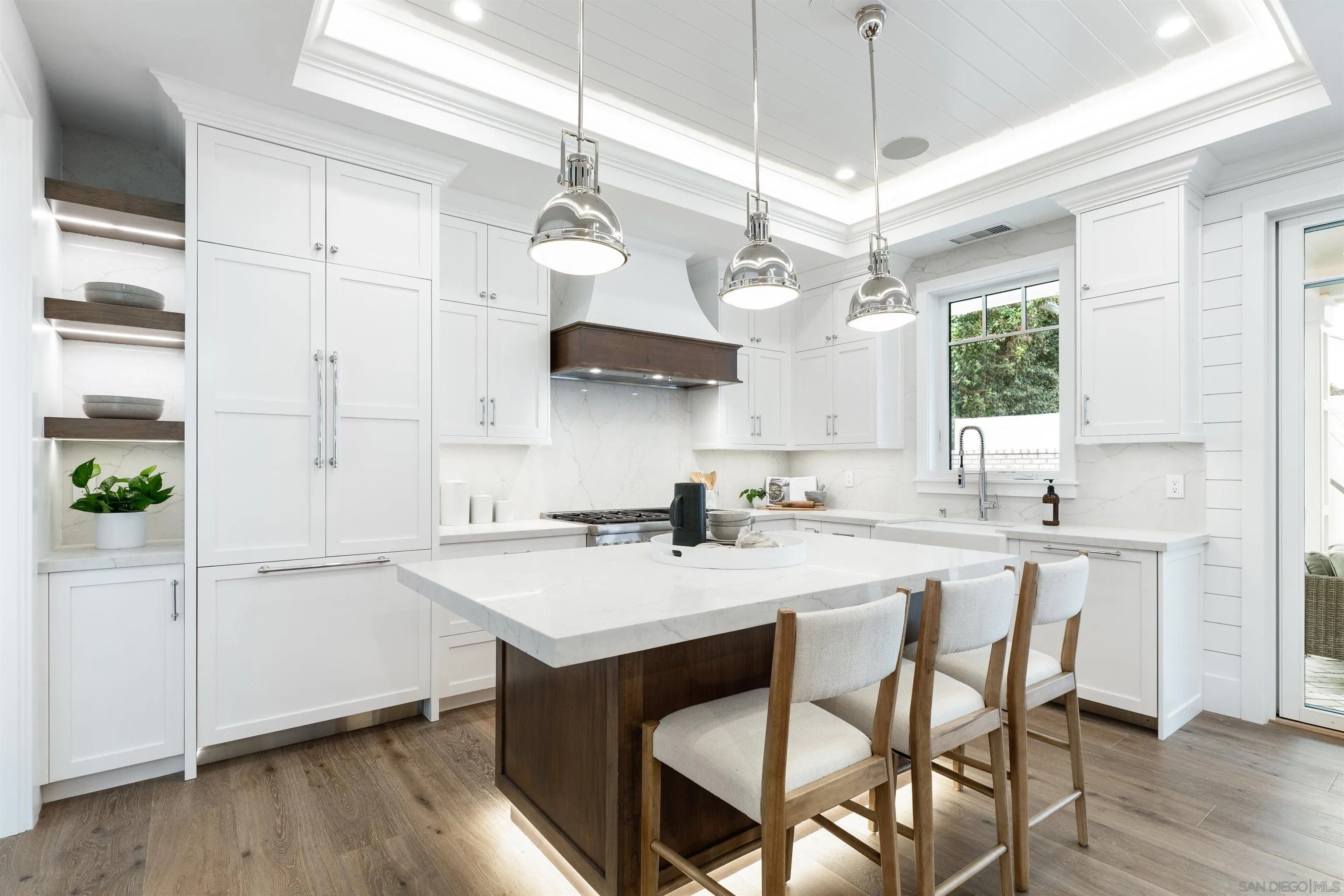 462 Westbourne Street La Jolla, CA 92037 - Photo 16 of 75 a kitchen with stainless steel appliances granite countertop a sink a stove a refrigerator and island with wooden floor