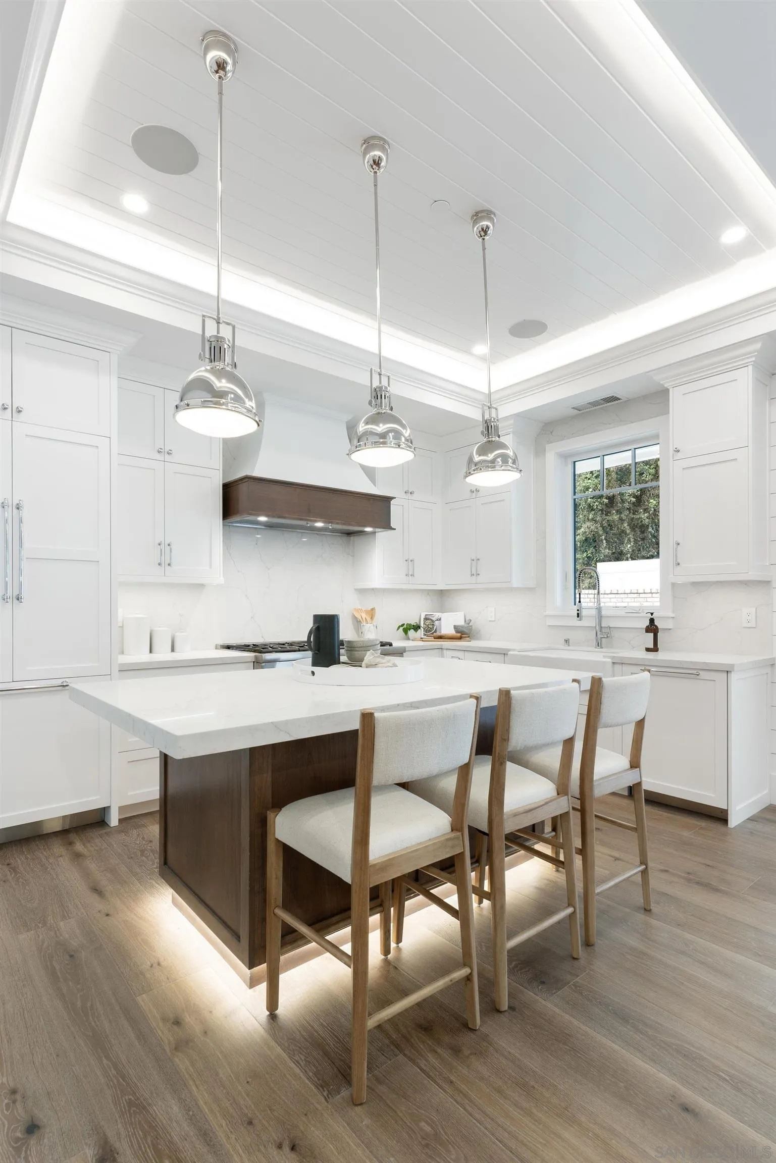 462 Westbourne Street La Jolla, CA 92037 - Photo 19 of 75 a kitchen with kitchen island granite countertop a sink a stove a dining table and chairs