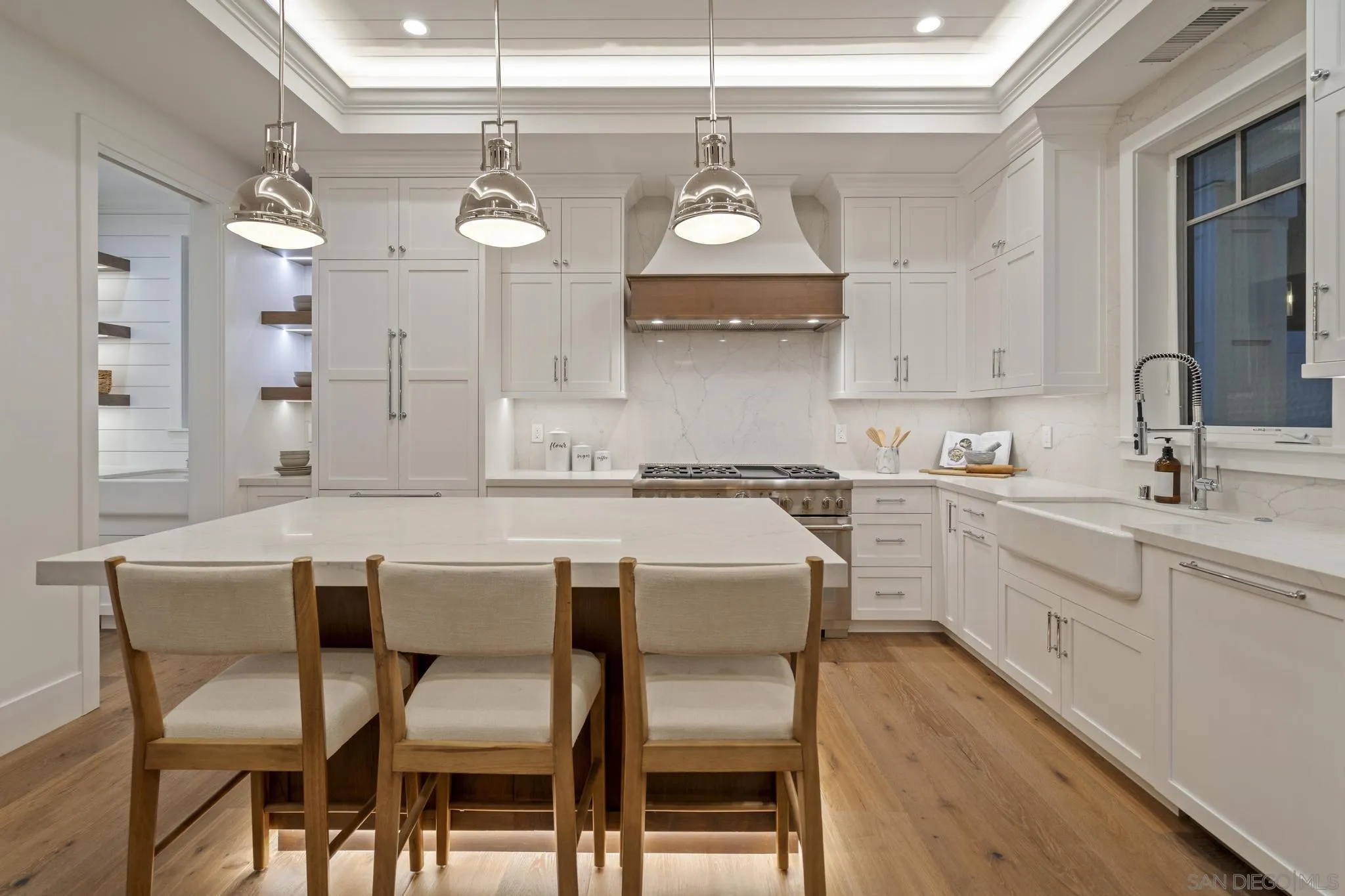 462 Westbourne Street La Jolla, CA 92037 - Photo 34 of 75 a kitchen with a dining table chairs wooden cabinets and wooden floor