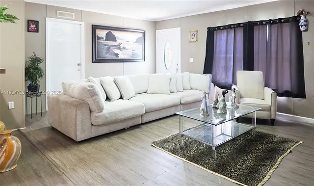 a living room with furniture and wooden floor