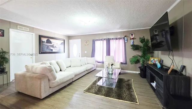 a living room with furniture a flat screen tv and a large window