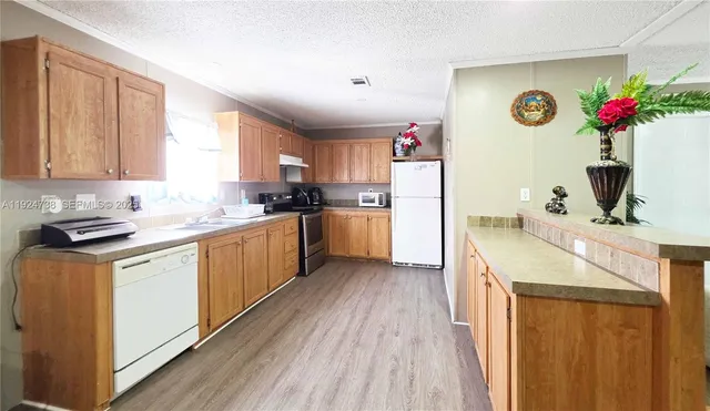 a kitchen with granite countertop a sink cabinets and wooden floor