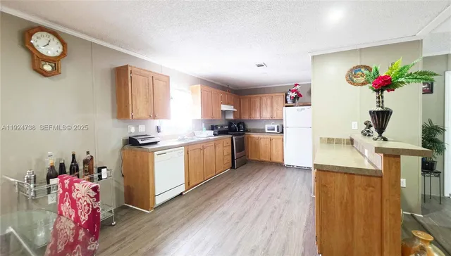 a kitchen with granite countertop a sink cabinets stainless steel appliances and a window