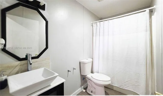 a bathroom with a sink toilet and mirror