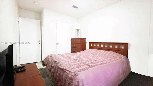 a bedroom with a bed and a television