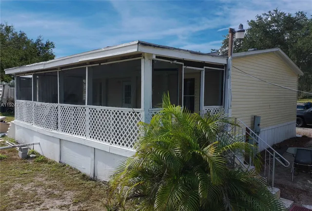 a view of a house with a small yard and wooden floor and fence