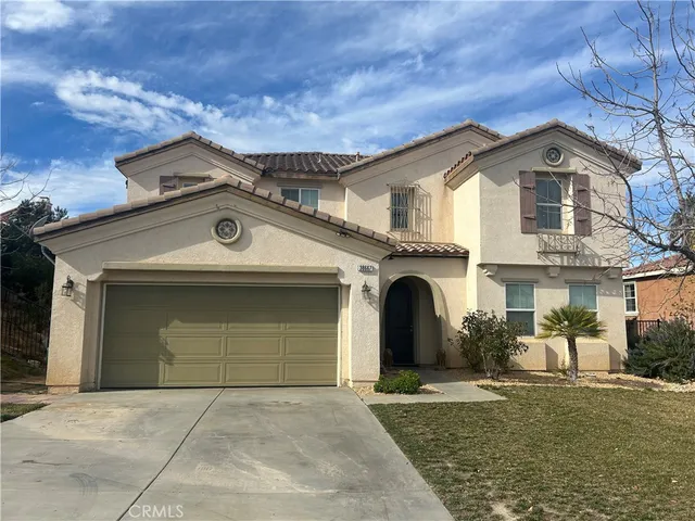 a view of a grey house with a garage
