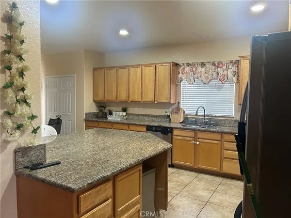 a kitchen with granite countertop kitchen island stainless steel appliances a sink stove and cabinets