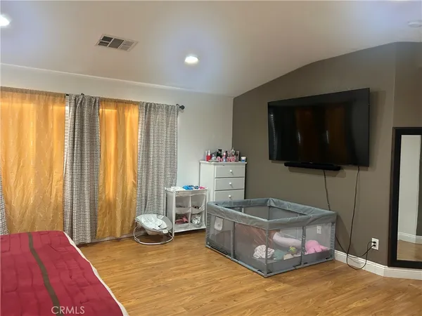 a bedroom with furniture and a flat screen tv