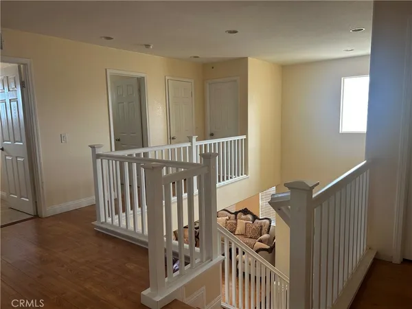 a view of a hallway with wooden floor and windows