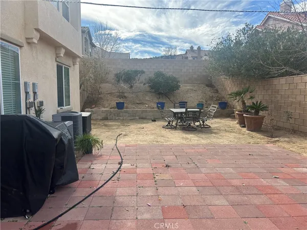 a view of a patio with table and chairs and potted plants