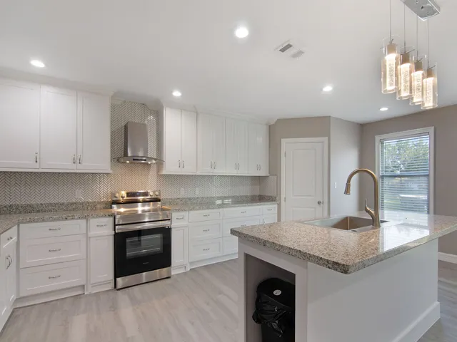 a kitchen with granite countertop white cabinets and appliances