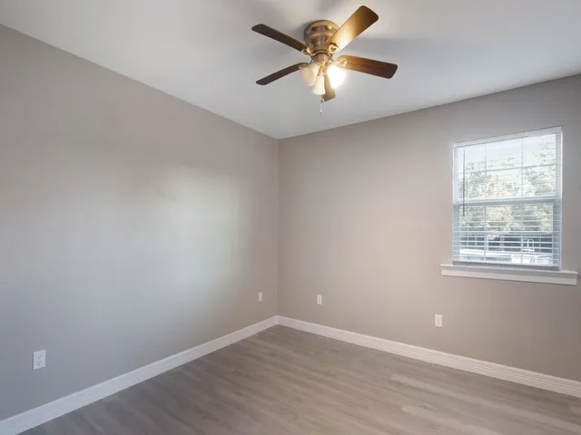 an empty room with a window and a fan