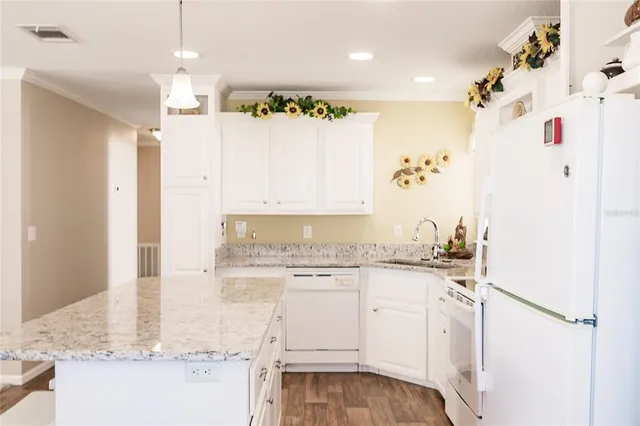 a kitchen with granite countertop white cabinets and white appliances