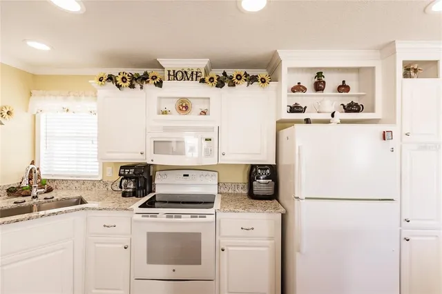 a kitchen with a refrigerator a stove a sink and a more cabinets