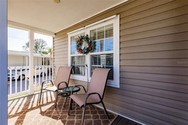 a view of a patio with table and chairs and wooden floor